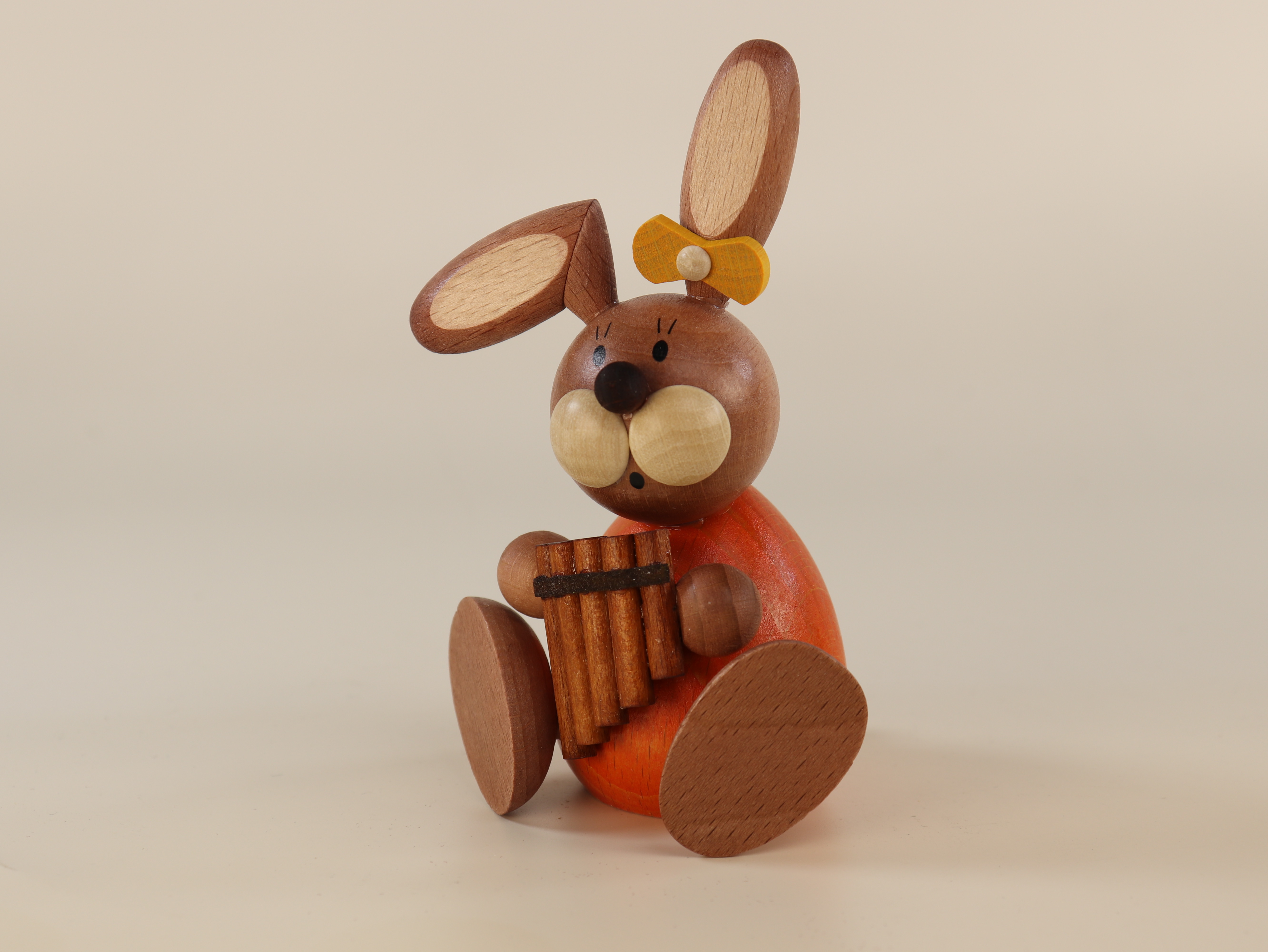 Sitzende Osterhäsin mit Panflöte als Tischschmuck