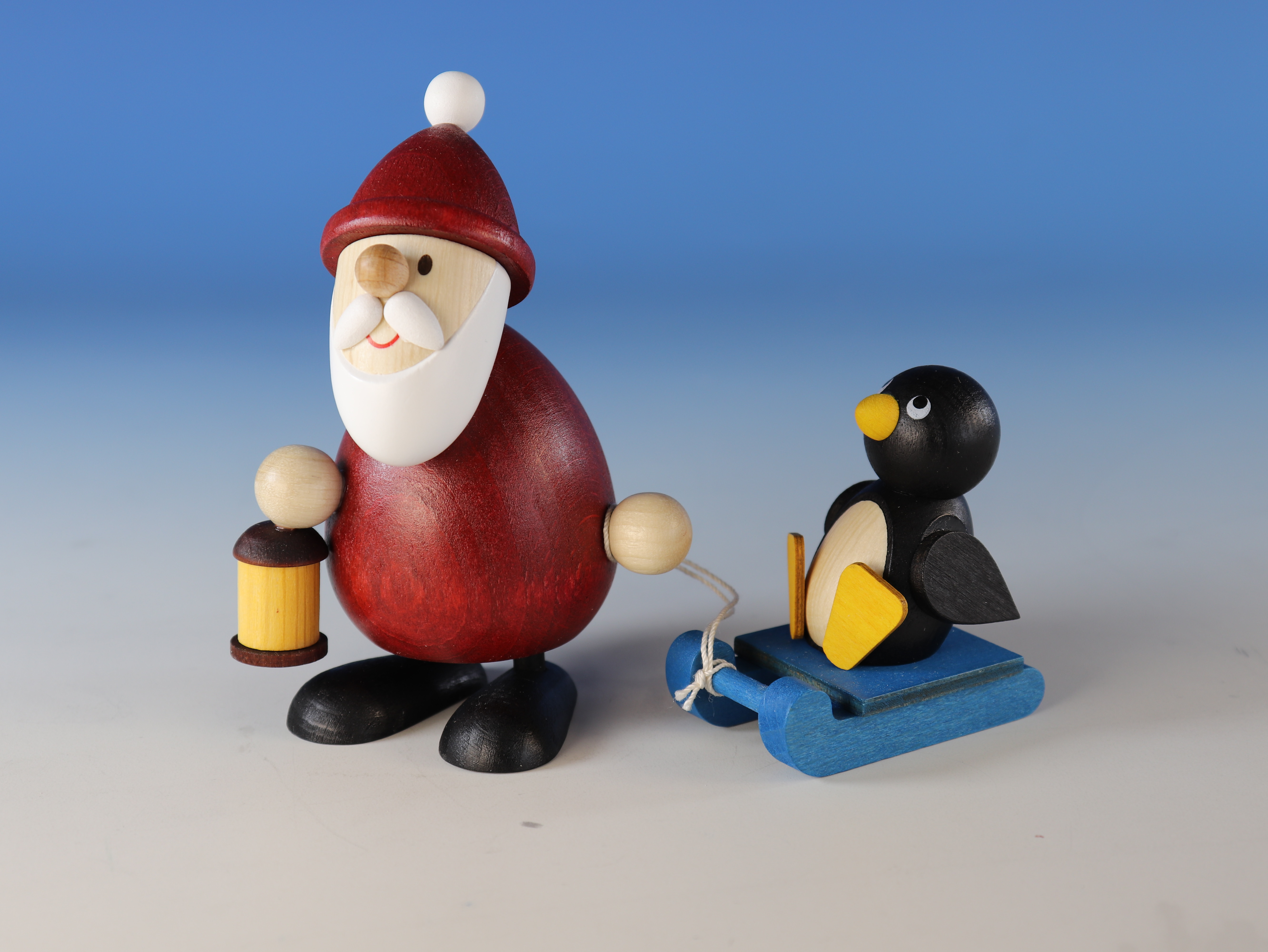 Weihnachtsmann mit Laterne & Pinguin auf Schlitten als Tischdekoration kaufen