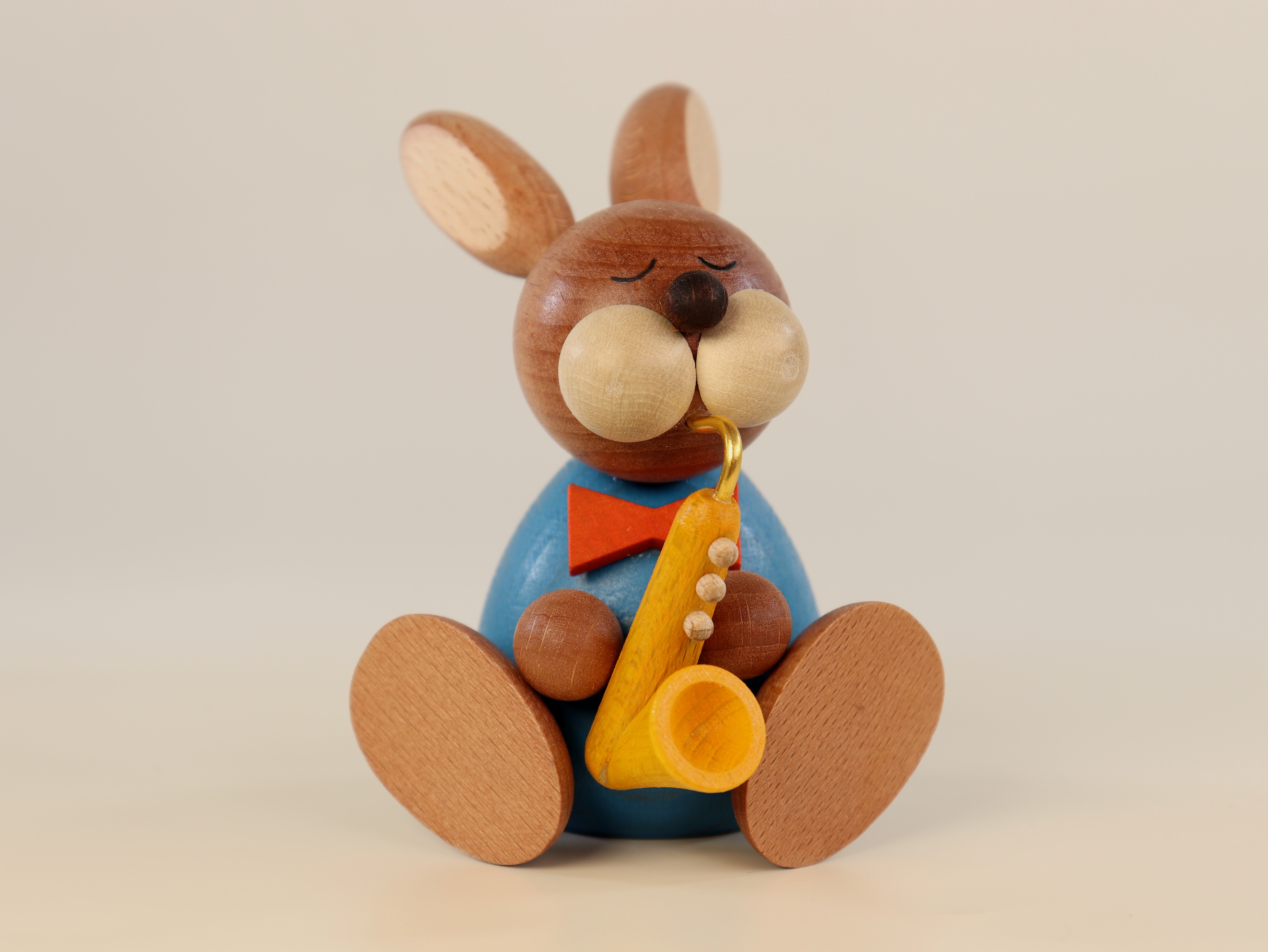Osterhase sitzend aus Holz mit Saxophon als Tischschmuck 