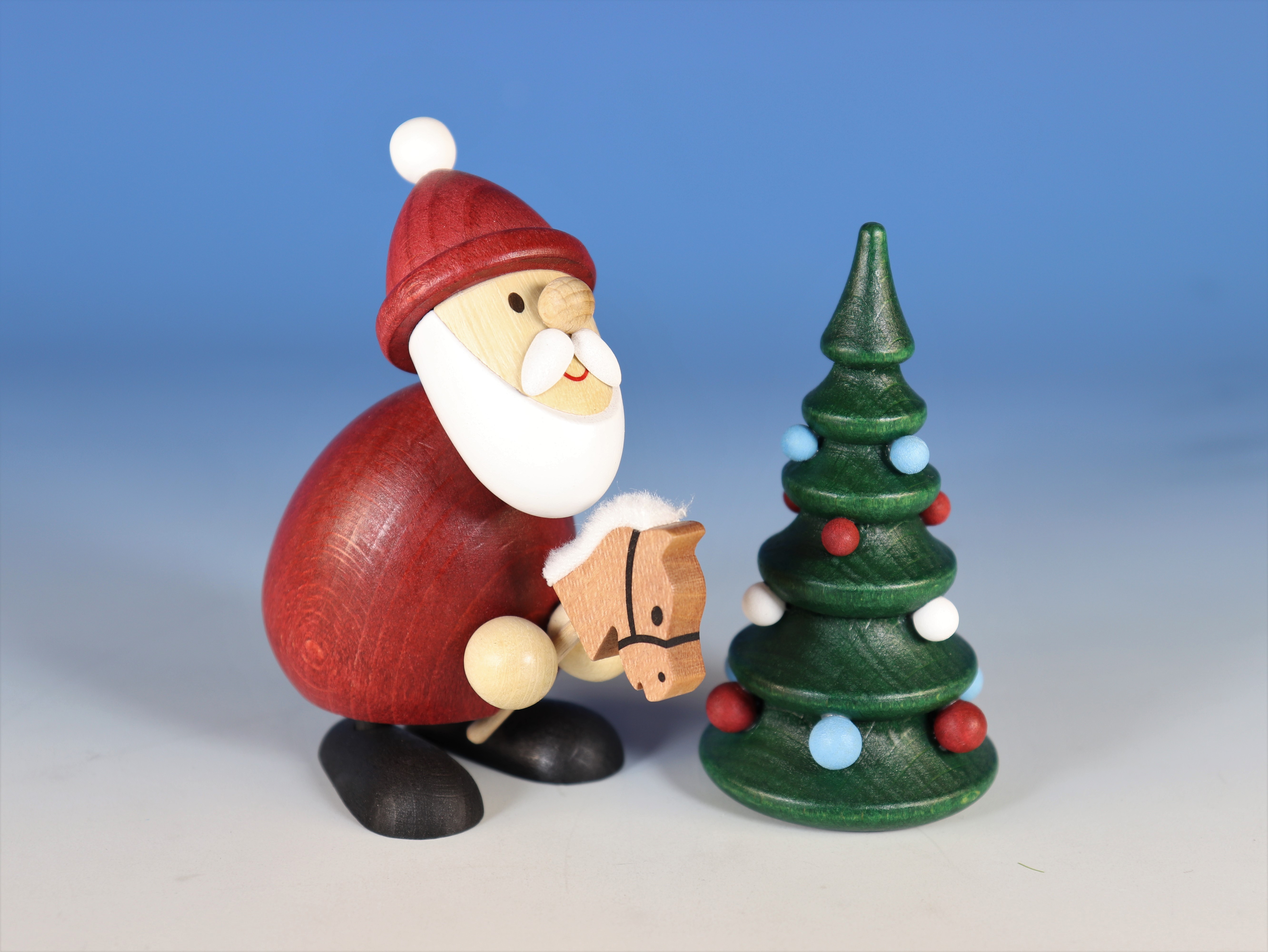 Weihnachtsmann mit Steckenpferd und Weihnachtsbaum als Tischschmuck