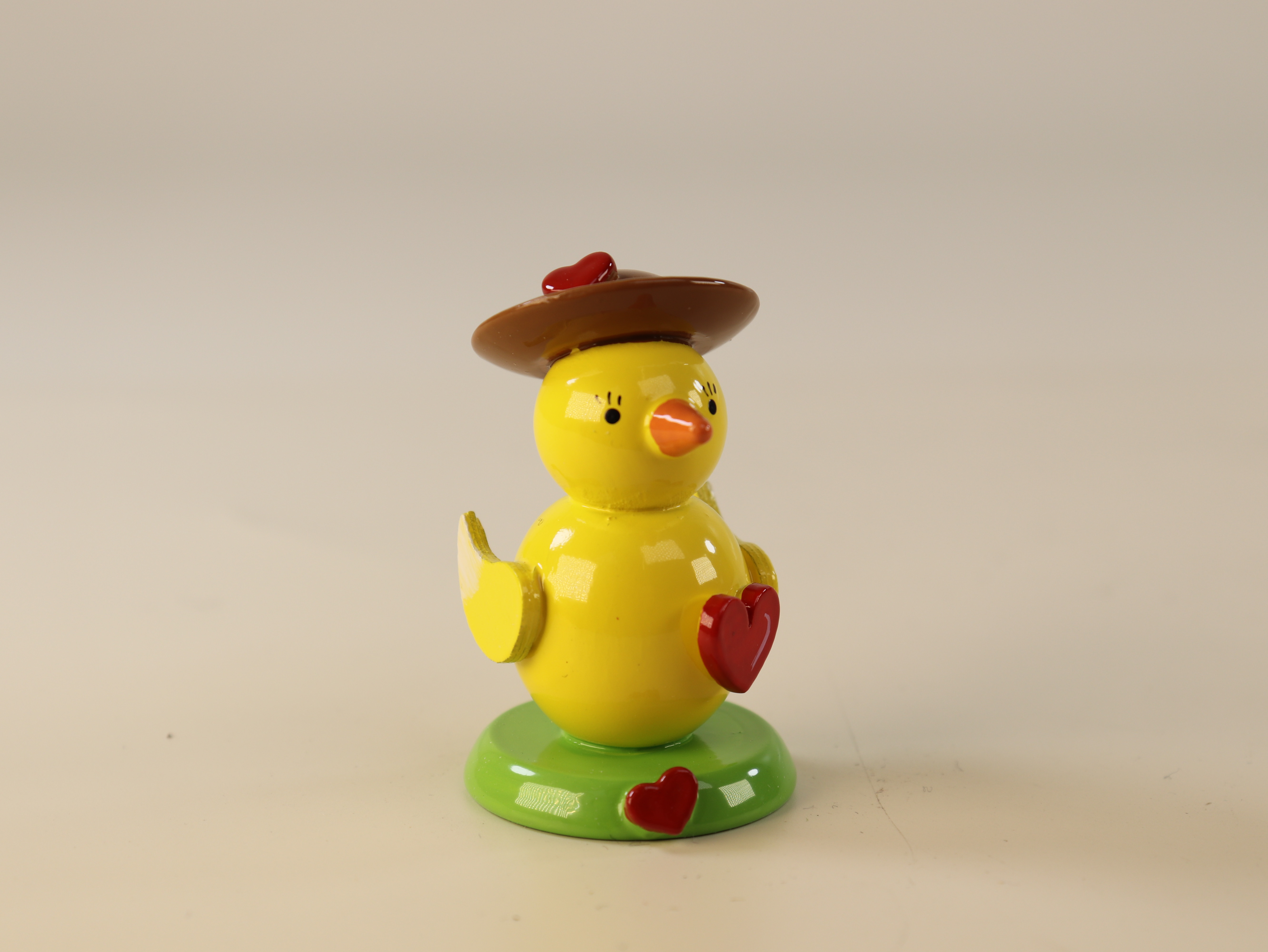  Osterschmuck Küken mit rotem Herz und Hut auf grünem Sockel
