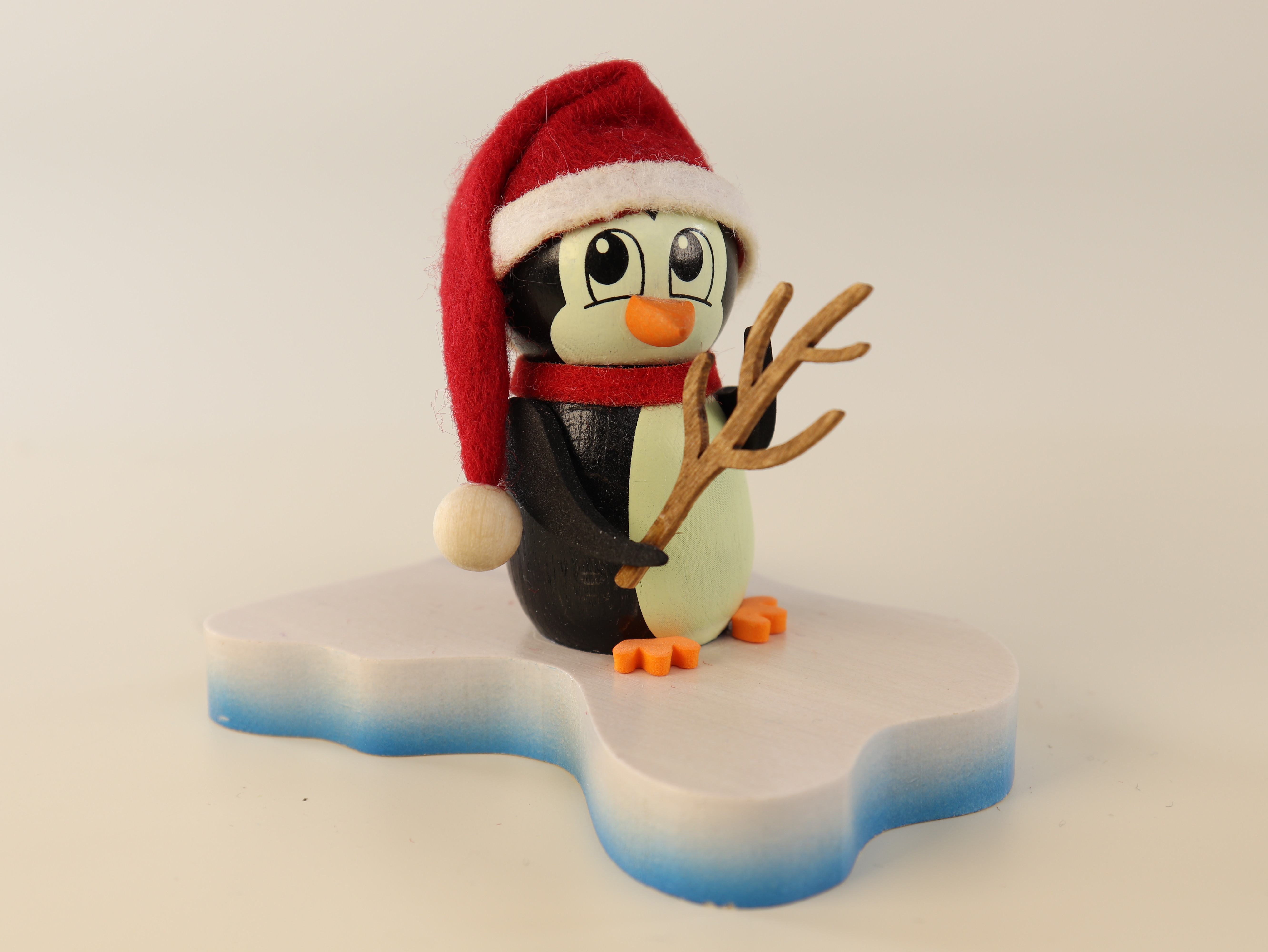 Tischschmuck aus Holz 'Pinguin auf Eisscholle mit Weihnachtsmütze und Rute' kaufen